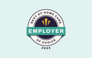 A circular badge with the text "Best of Home Care Employer of Choice 2022". The badge has a dark blue inner circle with three yellow lines at the top, and a white outer ring. A green banner with "Employer" in white letters crosses the middle of the badge.
