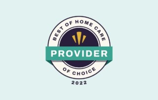A circular emblem with a light blue background reads "Best of Home Care Provider of Choice 2022." At the center is a dark circle with three yellow shapes, overlaid by a green banner with the word "Provider" in white letters.